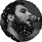 Playing bass and singing into the microphone, short hair and full beard